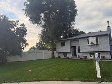 Charming home with a well-manicured lawn and mature trees providing shade at 3220 W 133Rd Cir, Broomfield, CO 80020