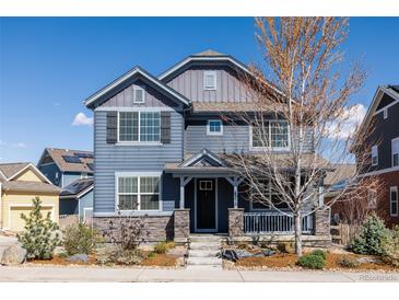 Charming two-story home with stone accents, a covered front porch, and manicured landscaping at 2879 Shadow Lake Rd, Lafayette, CO 80026
