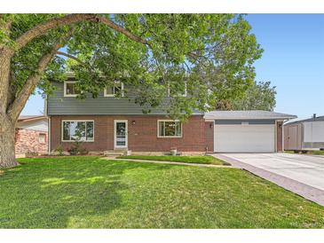 Charming two-story home with a well-manicured lawn, brick facade, and attached two car garage at 10826 Claire Ln, Northglenn, CO 80234