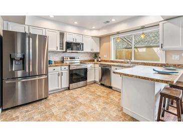 Bright kitchen with stainless steel appliances, tile backsplash, and countertops at 2891 S Vaughn Way, Aurora, CO 80014