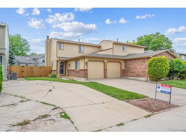 Charming two-story home with a two car garage, brick accents, and a well maintained front yard at 12702 Fairfax St, Thornton, CO 80241