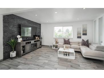 Bright living room featuring a stone accent wall, fireplace, and contemporary furnishings at 772 Lewiston St, Aurora, CO 80011