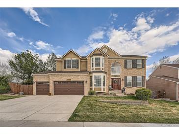 Charming two-story brick home with a manicured front yard and an attached two-car garage at 11710 Crow Hill Dr, Parker, CO 80134
