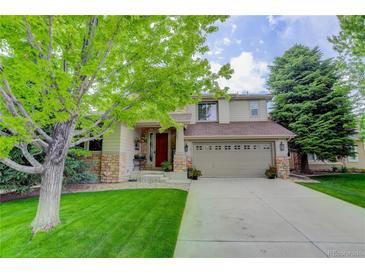 Charming two-story home featuring a well-manicured lawn and welcoming front porch at 10609 Chadsworth Ln, Highlands Ranch, CO 80126