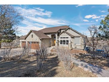 Charming exterior of a stone-clad home featuring a three-car garage and inviting walkway at 4249 Oak Grove Way, Castle Rock, CO 80108