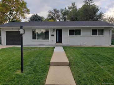 Charming single-story home with lush green lawn and inviting walkway, enhancing its curb appeal at 35 Everett St, Lakewood, CO 80226