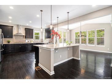 Spacious kitchen featuring dark cabinetry, pendant lighting, and large center island at 3522 Harvard Pl, Broomfield, CO 80023
