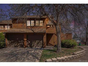 Inviting townhouse exterior with attached garages, wood siding, and a mature tree in the front yard at 2279 E 129Th Ave, Thornton, CO 80241
