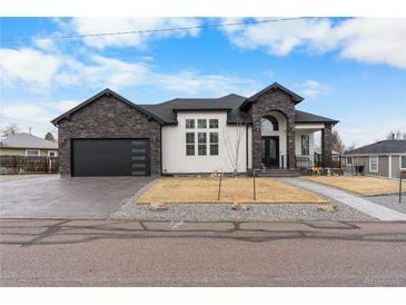 Striking single-Gathering home with a modern design, stone accents, and a well-manicured front yard at 12215 Viewpoint Dr, Lakewood, CO 80401