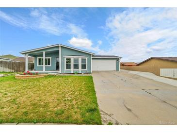 Charming home featuring a well-maintained lawn, covered porch, and an attached two-car garage at 243 Cherokee Ct, Brighton, CO 80603