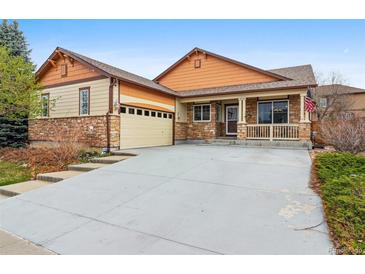 Charming home with stone accents, front porch, attached garage, and driveway at 2958 S Lisbon Way, Aurora, CO 80013