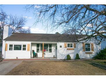 Charming single-story home featuring a white brick facade, complemented by wooden shutters and a well-maintained front yard at 3040 S Clermont Dr, Denver, CO 80222