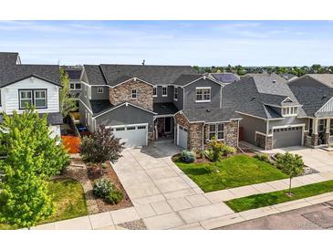 Beautiful two-story home boasting a large driveway, well-manicured lawn, and attractive stone and stucco facade at 15033 Delhi Ave, Parker, CO 80134
