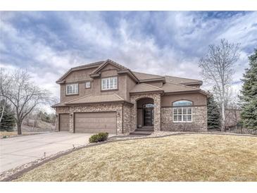 Stately two-story home featuring a three-car garage and stone and stucco exterior at 9315 E Aspen Hill Ln, Lone Tree, CO 80124