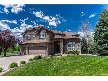 Beautiful two-story home featuring a well-manicured lawn and a three-car garage, perfect for Gathering living at 9315 E Aspen Hill Ln, Lone Tree, CO 80124