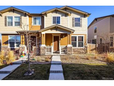 Charming two-story townhome with a welcoming front porch and well-maintained landscaping at 13725 Ash Cir, Thornton, CO 80602