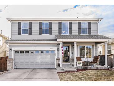 Charming two-story home with gray siding, black shutters, a two-car garage, and a cozy front porch at 11866 High Desert Rd, Parker, CO 80134