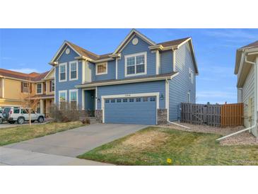 Beautiful two-story home featuring a blue exterior, well-manicured lawn, and attached two-car garage at 17216 E Trailmaster Dr, Parker, CO 80134