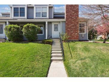 Inviting townhouse featuring a well-maintained lawn, charming facade, and brick chimney at 8220 W 90Th Pl # 2003, Broomfield, CO 80021