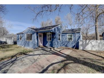 Quaint home featuring a new driveway, pink door, and mature trees at 4260 Newland St, Wheat Ridge, CO 80033