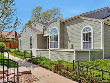 Charming exterior view of townhome with well-maintained landscaping, walkway and large arched windows at 5872 W Asbury Pl, Lakewood, CO 80227