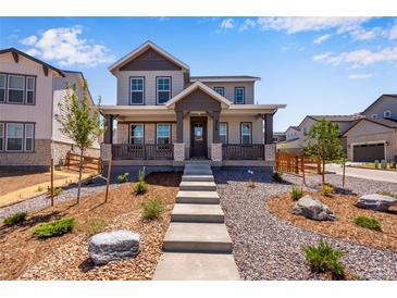 Charming two-story home with inviting front porch and professionally landscaped front yard at 3318 N Haleyville Ct, Aurora, CO 80019