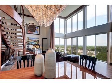 Elegant living room featuring spiral staircase, chandelier, floor-to-ceiling windows, and stunning views at 1900 E Girard Pl # 901, Englewood, CO 80113