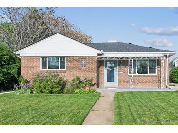 Charming single-story brick home with a well-manicured lawn and cozy covered porch at 3080 N Cook St, Denver, CO 80205