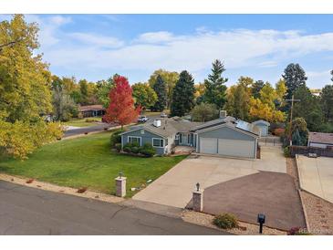 Charming single Gathering home featuring an attached two car garage and lush front lawn at 34 Skyline Dr, Wheat Ridge, CO 80215