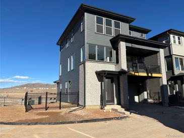 Modern three-story townhome with gray and white exterior, and a fenced yard at 3104 S Russell St, Morrison, CO 80465