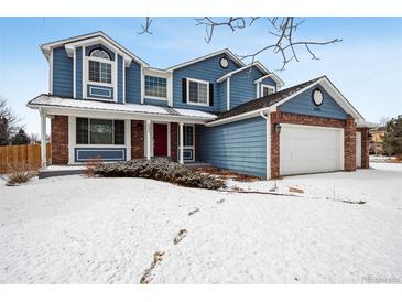 Charming two-story home with a red front door and a two-car garage, perfect for a Gathering at 5395 S Flanders Way, Centennial, CO 80015