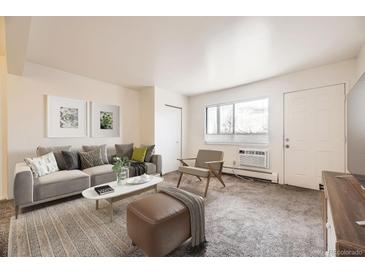 Bright living room featuring a plush sofa, modern decor, and natural light streaming through a large window at 5995 W Hampden Ave # 8C, Denver, CO 80227