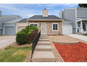 Charming townhome featuring a stone facade, well-manicured landscaping, and a welcoming front entrance at 19616 E Milan Cir, Aurora, CO 80013