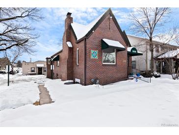 Charming brick home with a traditional design and a snow-covered yard at 2606 W Alamo Ave, Littleton, CO 80120