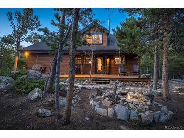 Charming log home featuring a welcoming front porch and a beautifully landscaped yard with natural rock features at 44 Linn Ln, Golden, CO 80403