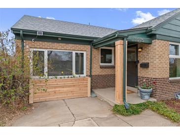Charming brick home featuring a welcoming front entrance, flower box and freshly landscaped accents at 3075 N Elm Ave, Denver, CO 80207