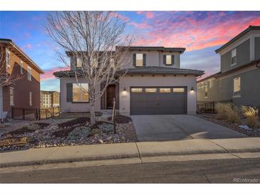 Stunning two-story home featuring a covered entryway, manicured yard, and a two-car garage at 10659 Montecito Dr, Lone Tree, CO 80124