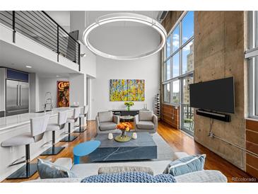 Spacious living room featuring concrete wall, modern decor, and floor-to-ceiling windows with city views at 1050 Cherokee St # 403, Denver, CO 80204