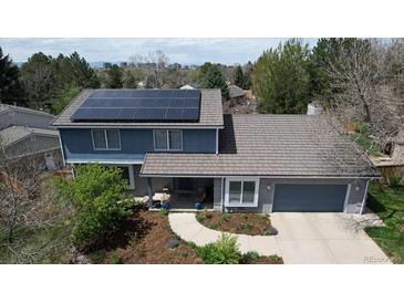 Aerial view of a charming two-story home featuring solar panels and an attached garage at 6062 S Emporia Cir, Englewood, CO 80111