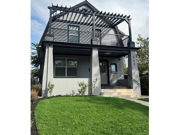 Charming two-story home features a striking pergola and a well-manicured front yard with lush green grass at 544 N Logan St, Denver, CO 80203