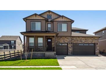 Charming two-story home with a well-manicured lawn, a two car garage and stone detailing at 1876 Chaffee Crest Dr, Berthoud, CO 80513