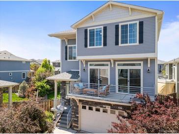 Charming two-story home with a private balcony above the garage and beautiful blue horizontal siding at 239 S Old Hammer St, Aurora, CO 80018