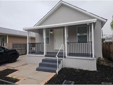 Charming single-Gathering home featuring covered porch, gray paint, and manicured landscaping at 4673 Sherman St, Denver, CO 80216