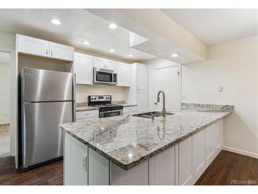 Bright kitchen features stainless steel appliances, white cabinetry, and granite countertops at 9427 W 89Th Cir, Broomfield, CO 80021
