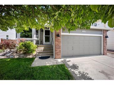 Charming two-story home with attached garage and inviting front yard, shaded by a large tree at 5750 S Youngfield St, Littleton, CO 80127
