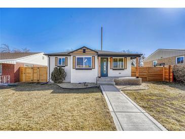 Charming renovated white brick home featuring a manicured lawn and a welcoming walkway at 1328 Holly St, Denver, CO 80220