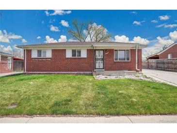 Charming brick home featuring a well-maintained lawn and classic design elements under a bright sky at 5510 Troy St, Denver, CO 80239