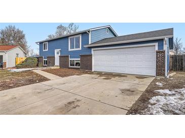 Ranch style home with blue siding, brick accents, and a two-car garage at 15934 E Columbia Pl, Aurora, CO 80013