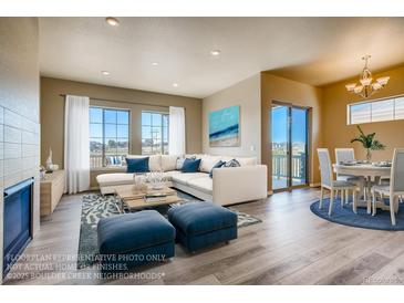 Spacious living room with L-shaped sofa, fireplace, and access to a deck at 841 W 128Th Pl, Westminster, CO 80234