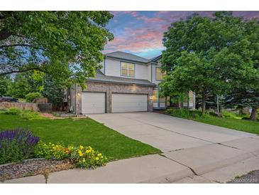 Charming two-story home with a well-manicured lawn, mature trees, and a spacious three-car garage at 6506 S Robb Way, Littleton, CO 80127